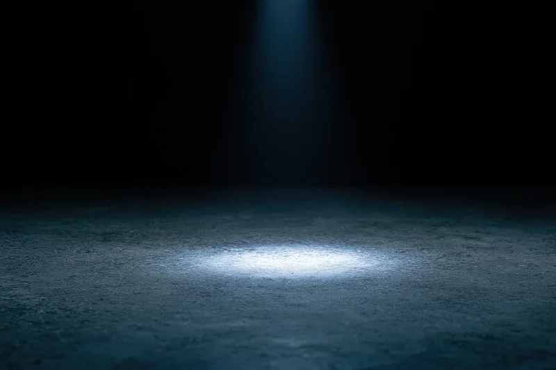 Spotlight on concrete floor in dark studio space