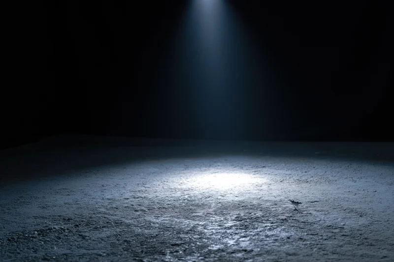 Spotlight beam on empty concrete floor in dark studio space