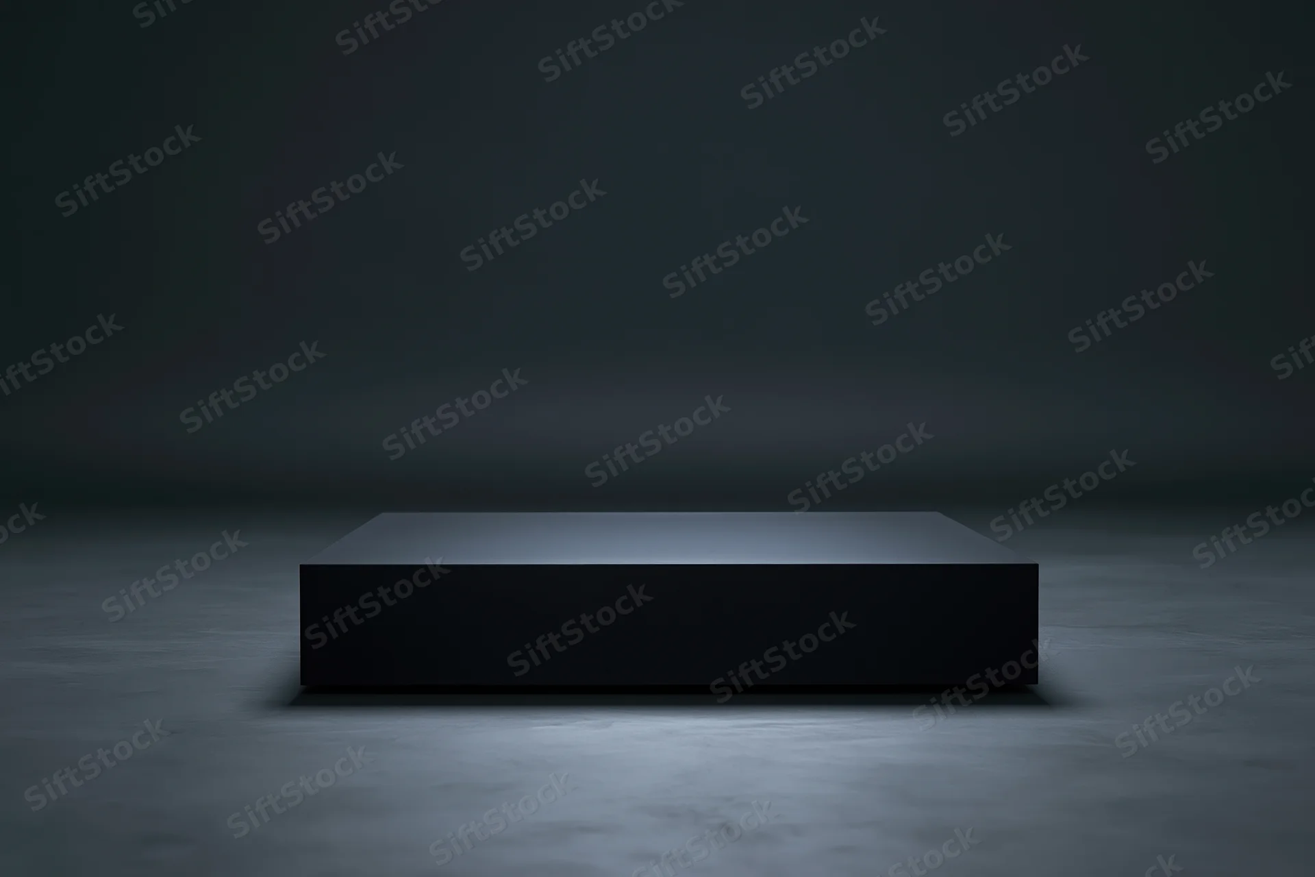 Matte black rectangular pedestal centered on a dark concrete floor under spotlight in a studio setting