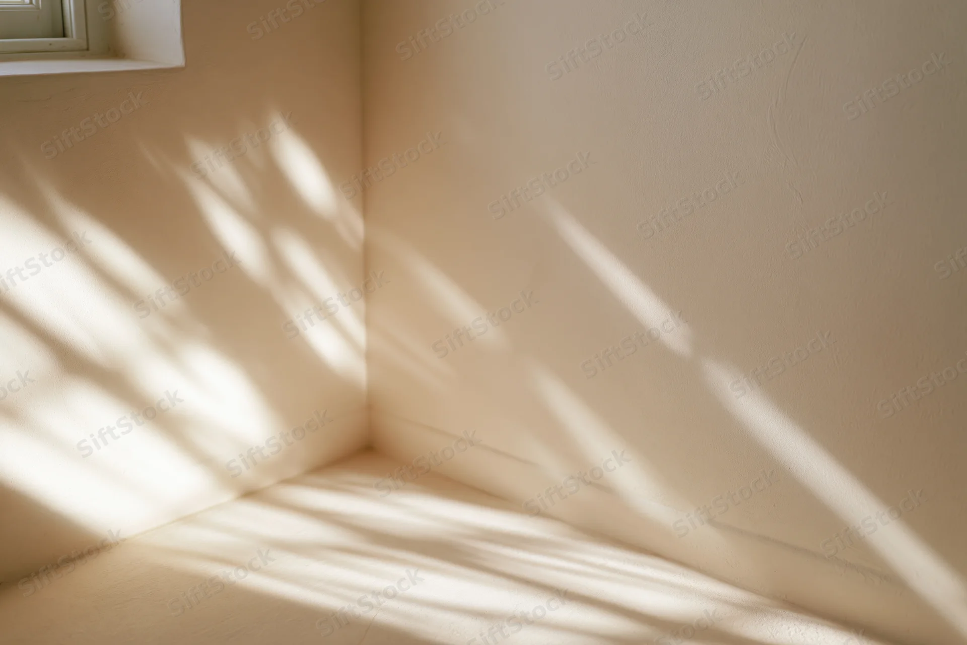 Sunlight casting striped shadows across a minimalist room corner with beige walls and a window frame