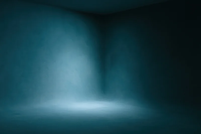 Empty studio space with curved seamless backdrop and spotlighted floor in dark blue tones
