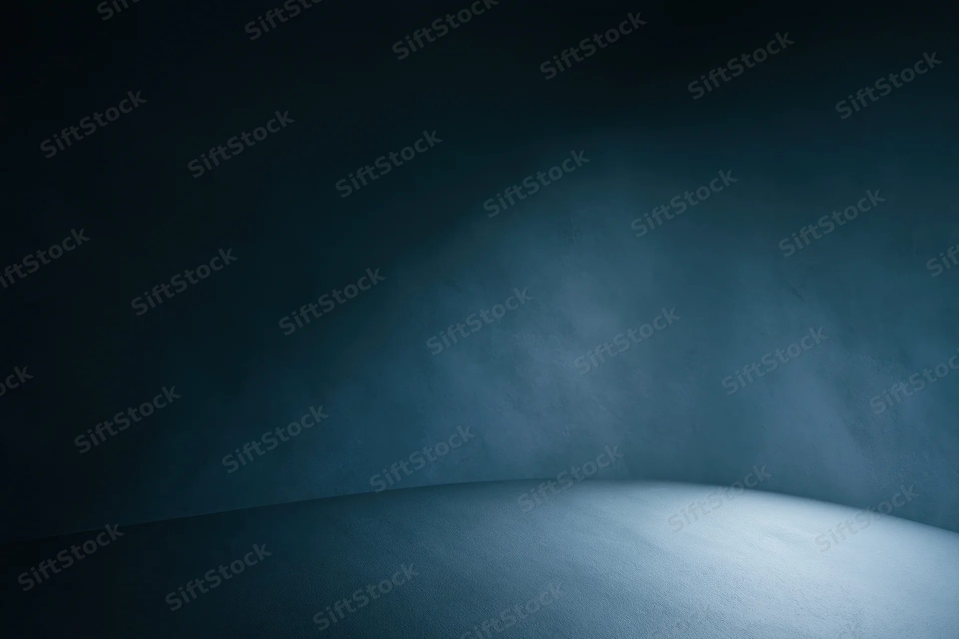 Curved seamless backdrop in a photography studio with spotlight and shadow