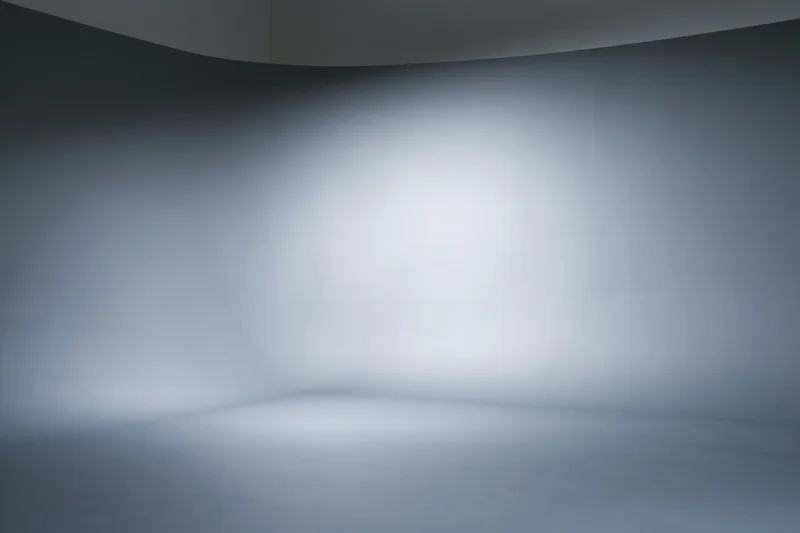 Empty professional photo studio with seamless grey curved backdrop and soft lighting