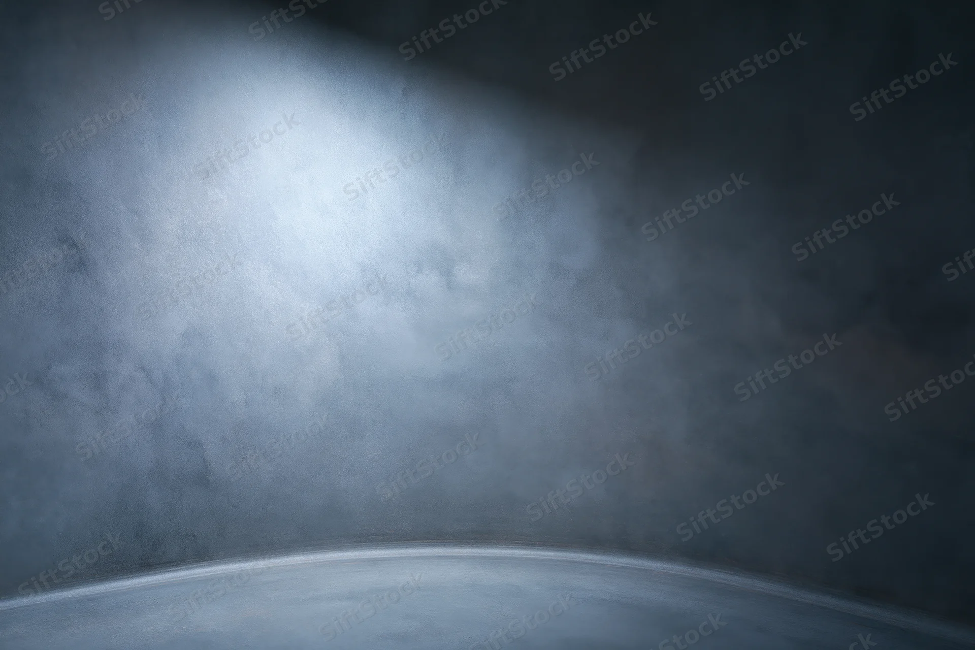 Curved seamless studio backdrop with spotlight and shadowed corners