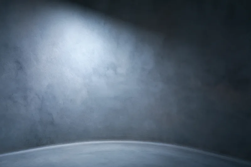 Curved seamless studio backdrop with spotlight and shadowed corners