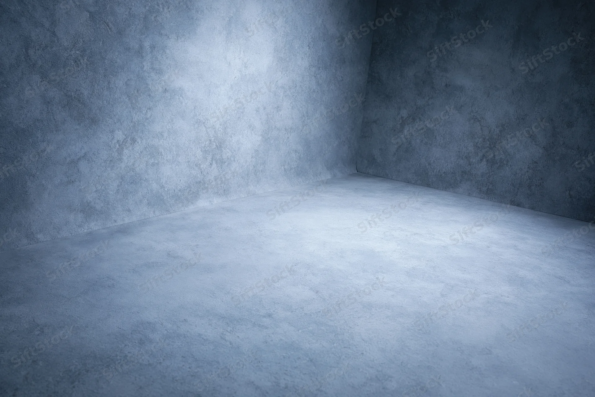 Empty studio corner with seamless curved walls and concrete floor under cool lighting