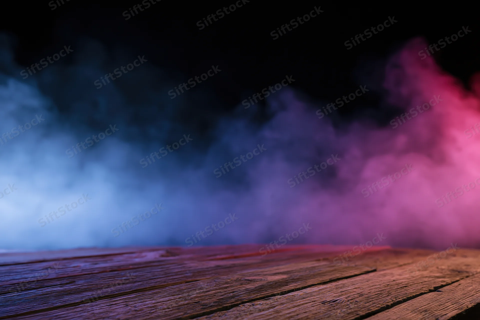 Low-angle view of empty wooden surface with colorful smoke against black background