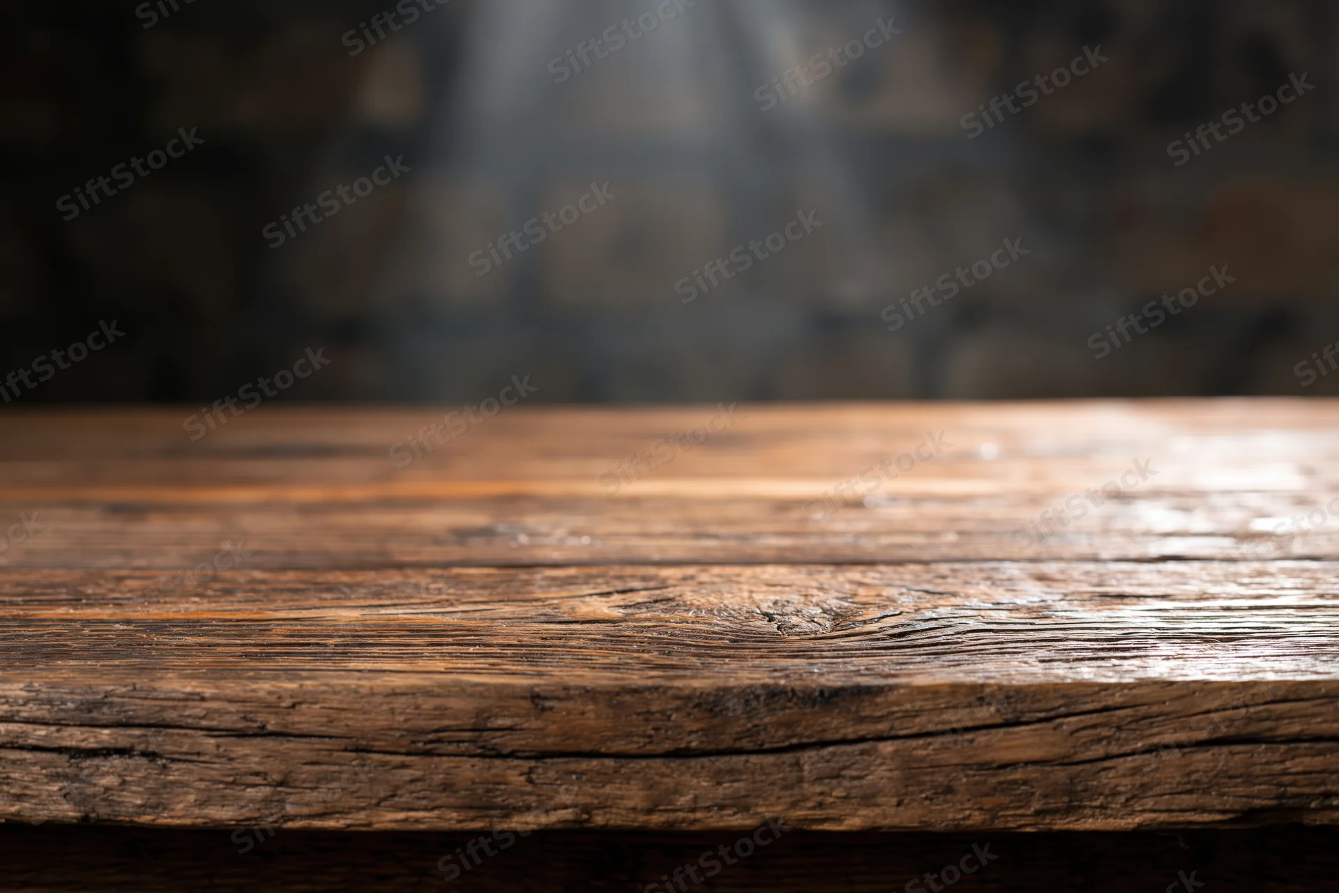 Worn wooden tabletop in a dimly lit rustic interior with blurred background and copyspace