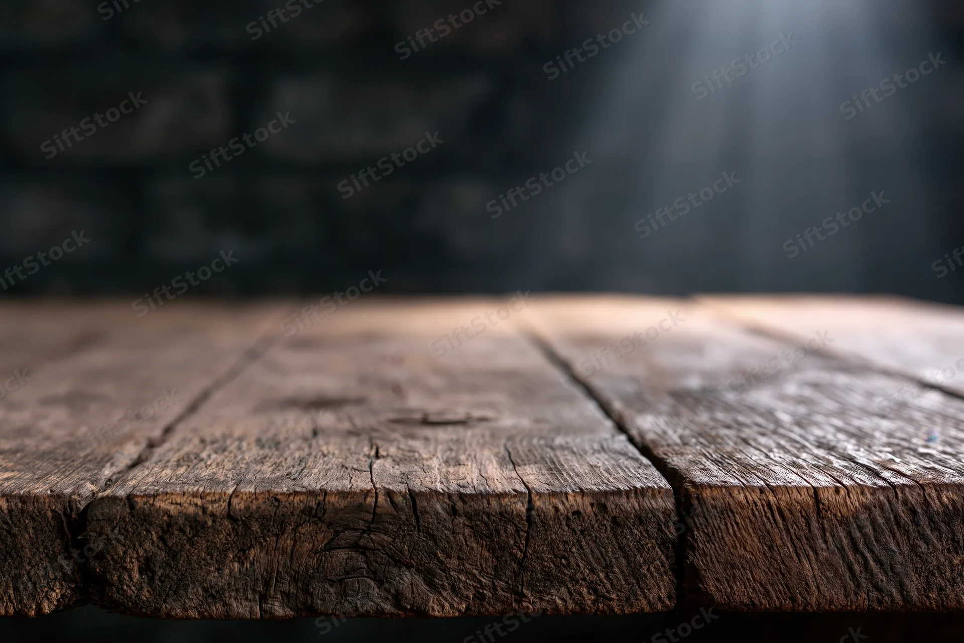Worn wooden tabletop with dark blurred background and copyspace