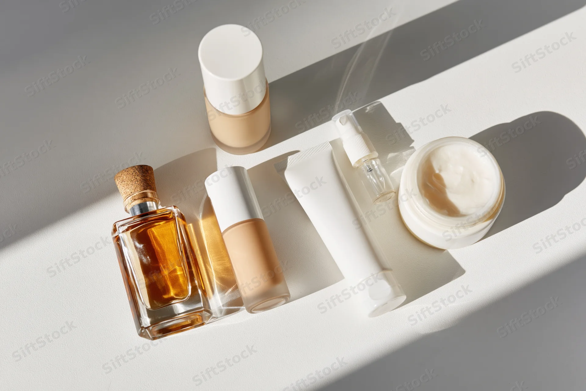 Skincare and cosmetic products arranged on a white surface in soft light