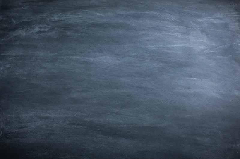 Dark grey chalkboard surface with subtle texture and faint smudges filling the frame