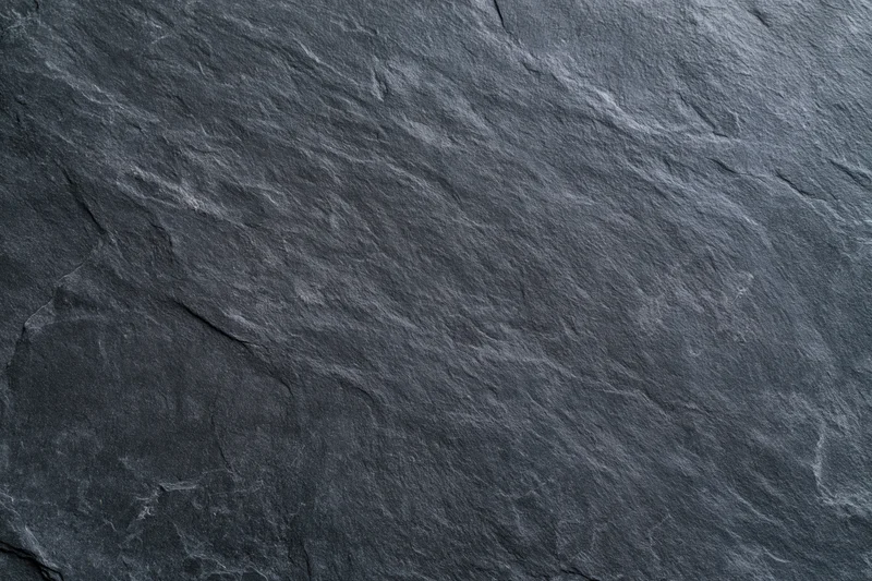 Close-up of dark slate stone surface with natural texture and cracks