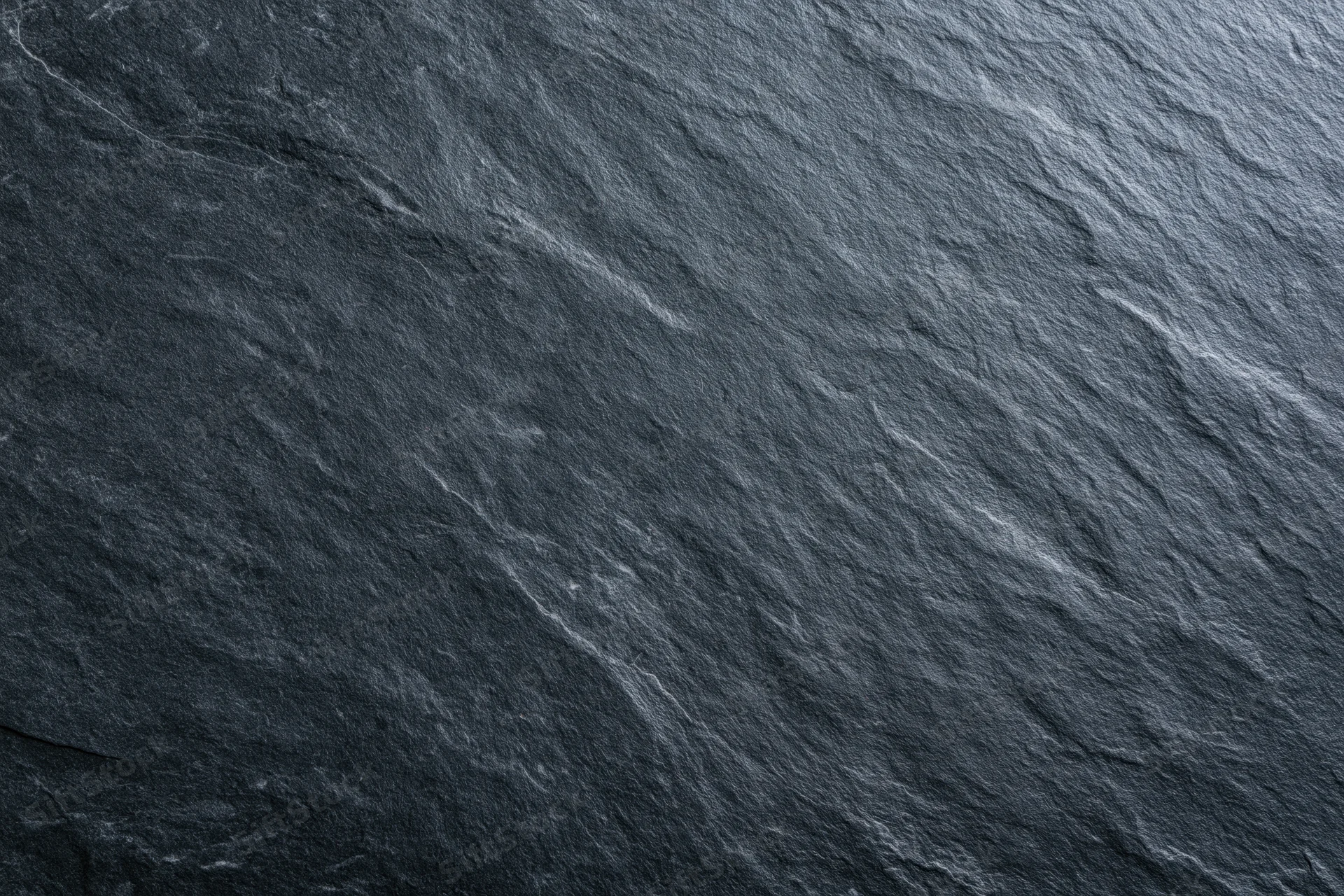 Close-up of dark slate stone surface with natural texture and veining
