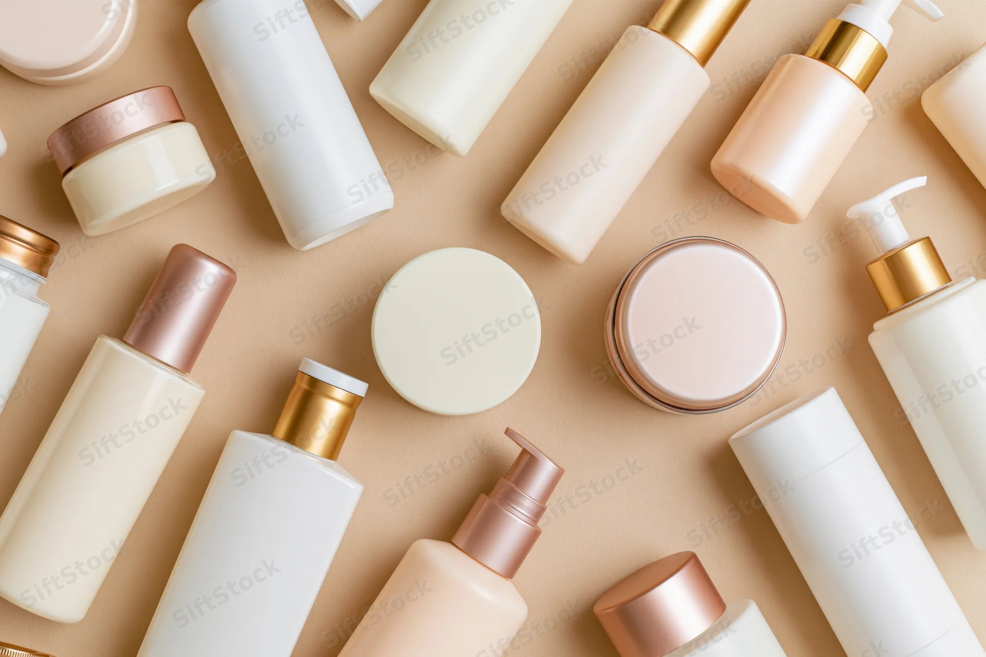 Assorted skincare and beauty product containers arranged in flat lay on beige background