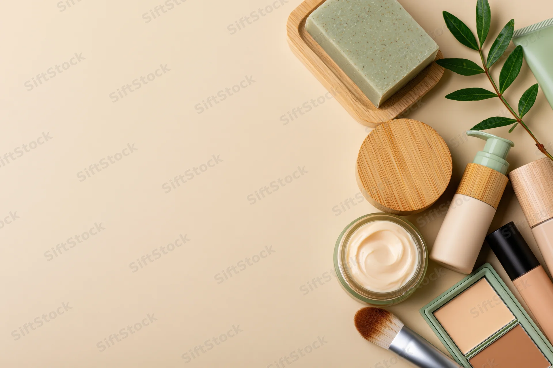 Eco-friendly skincare and makeup products arranged in flat lay on beige surface with bamboo and green leaf accents