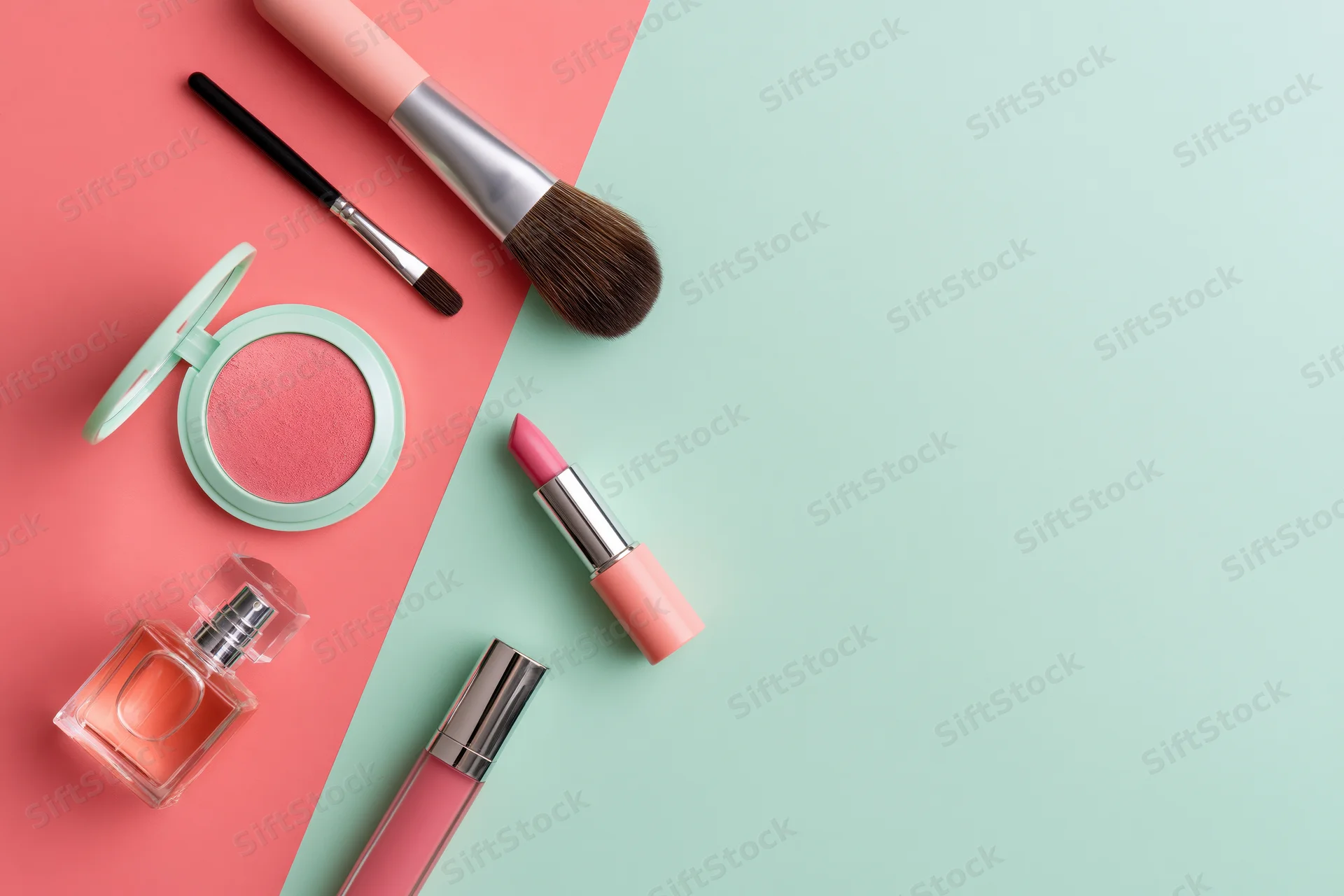 Makeup products arranged on a split pink and mint background with copyspace