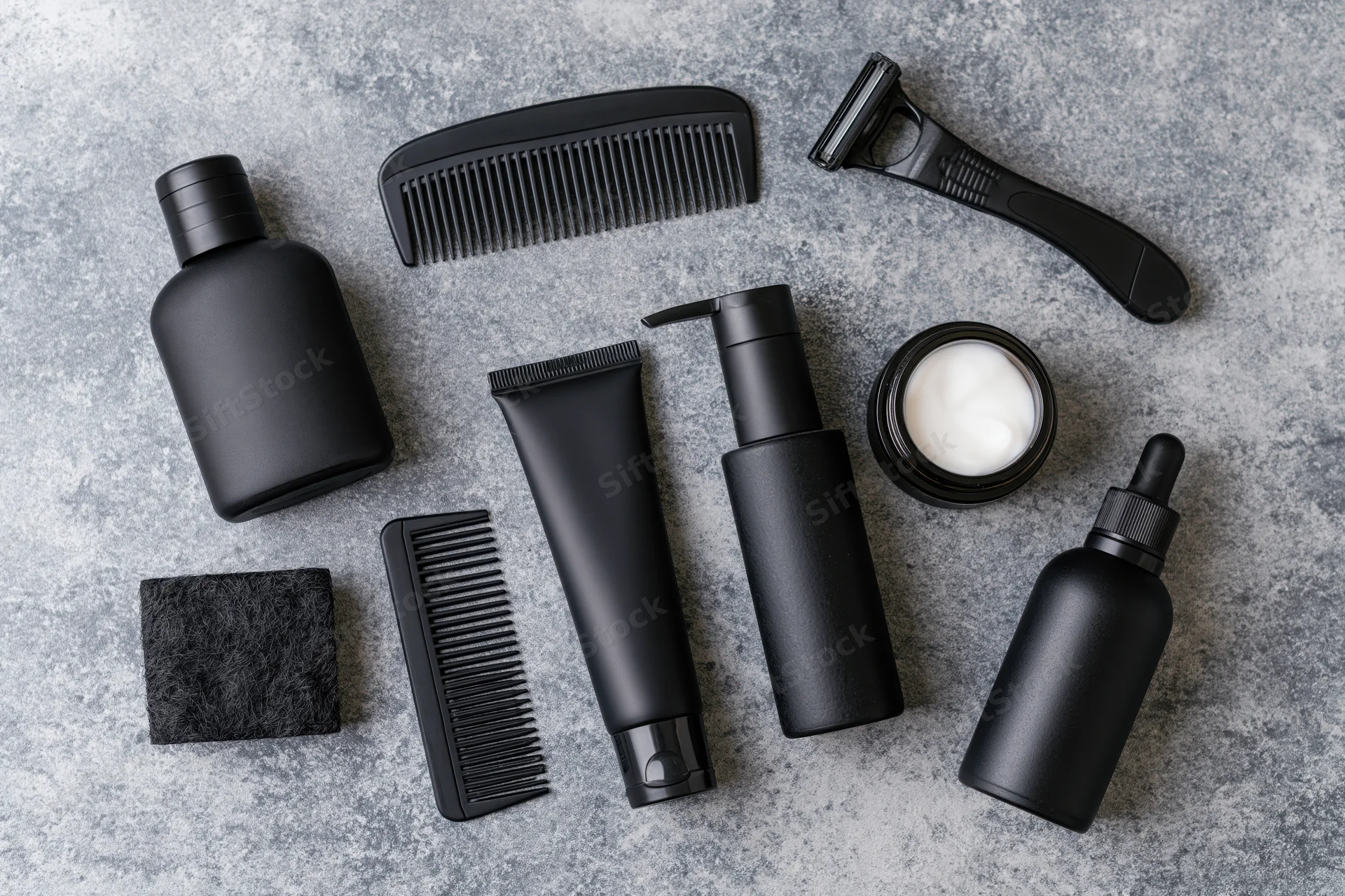 Men's grooming products arranged in flat lay on textured gray surface