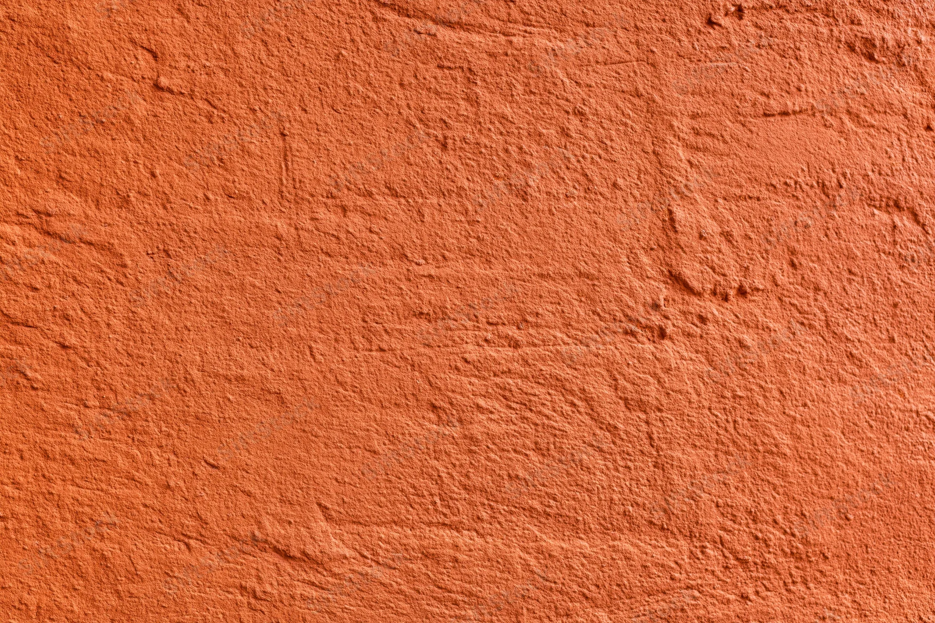 Textured stucco wall painted in deep burnt orange, showing rough plaster surface