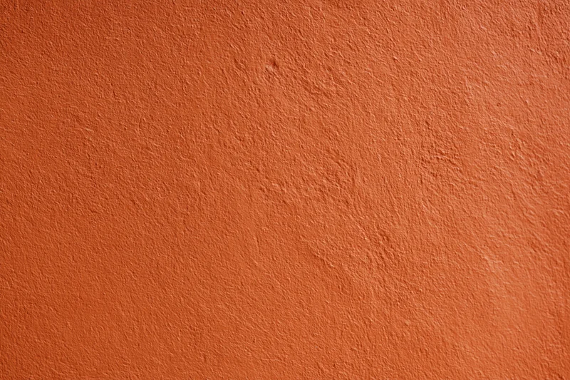 Textured orange stucco wall surface filling the frame