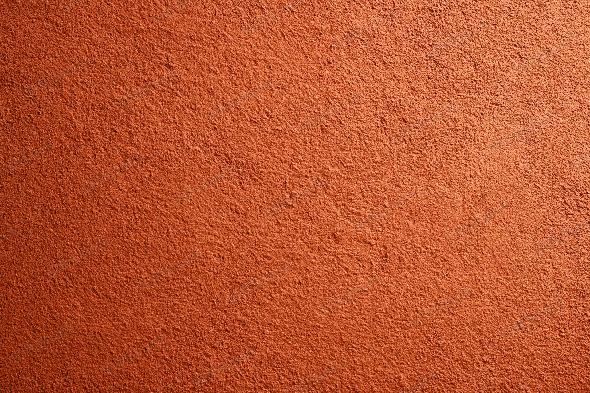 Textured burnt orange stucco wall surface