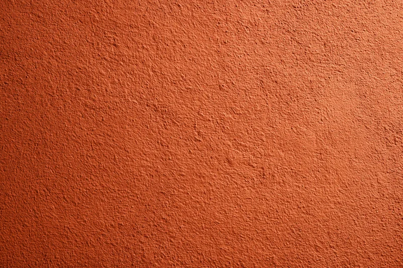 Textured burnt orange stucco wall surface