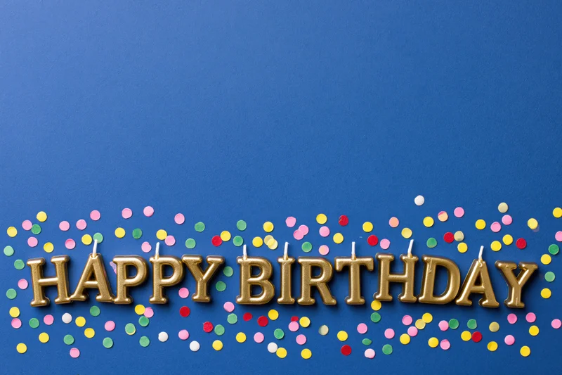 Gold letter candles spelling HAPPY BIRTHDAY on blue background