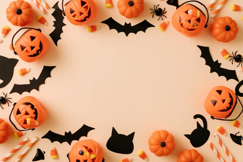 Halloween decorations arranged in a flat lay frame on a light background