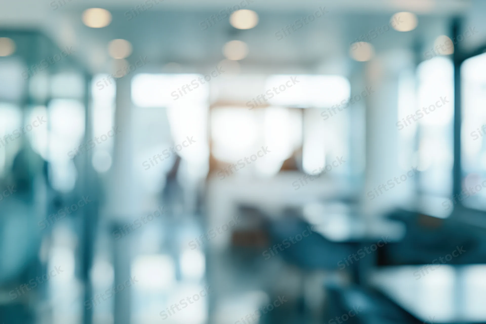 Blurred interior of a modern office lobby with glass walls and tables
