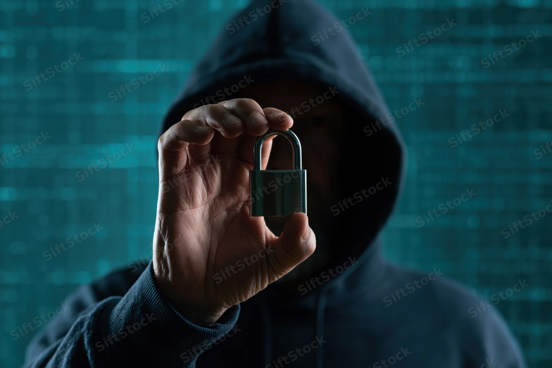 Hooded figure holding a padlock in front of a digital code background
