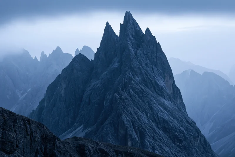 Jagged dolomite mountain peaks rising sharply against a stormy sky