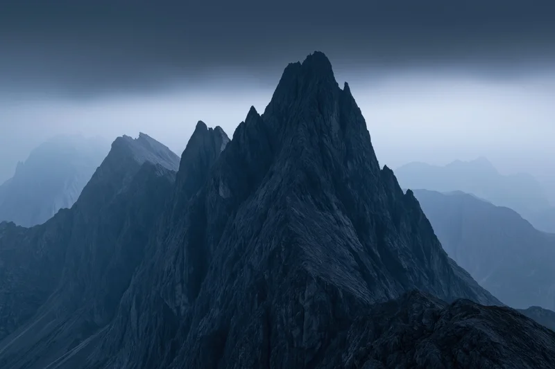 Jagged dolomite mountain peaks rising sharply against a stormy sky