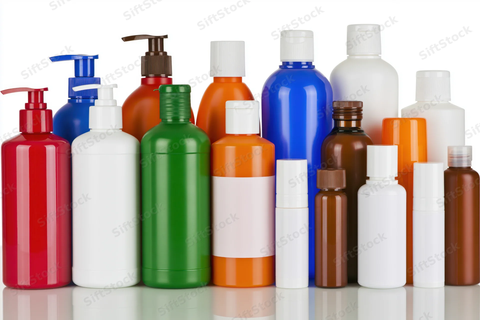 Colorful plastic bottles for personal care products arranged in a row on a reflective white surface