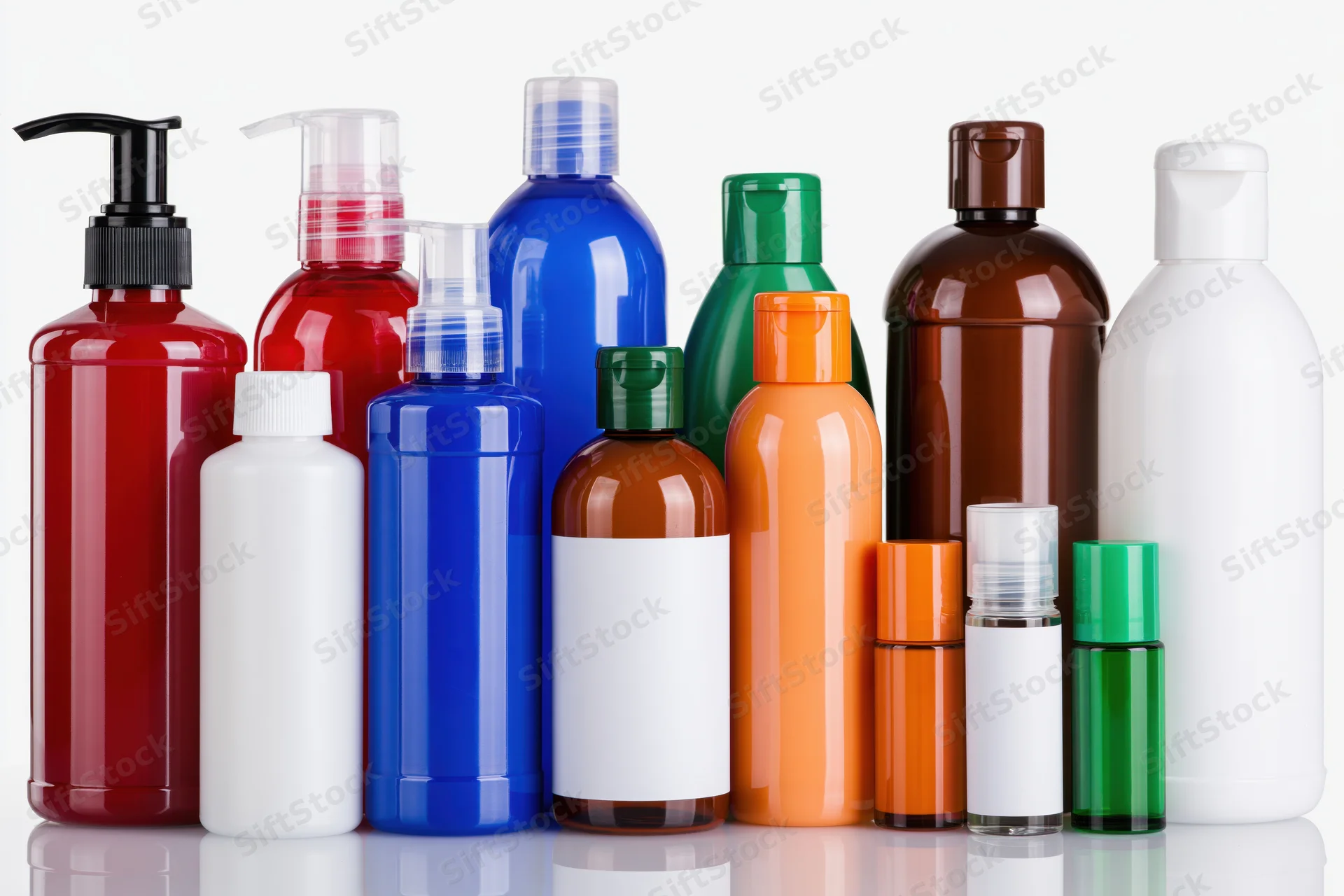 Colorful plastic bottles for personal care products arranged in a row on a white reflective surface