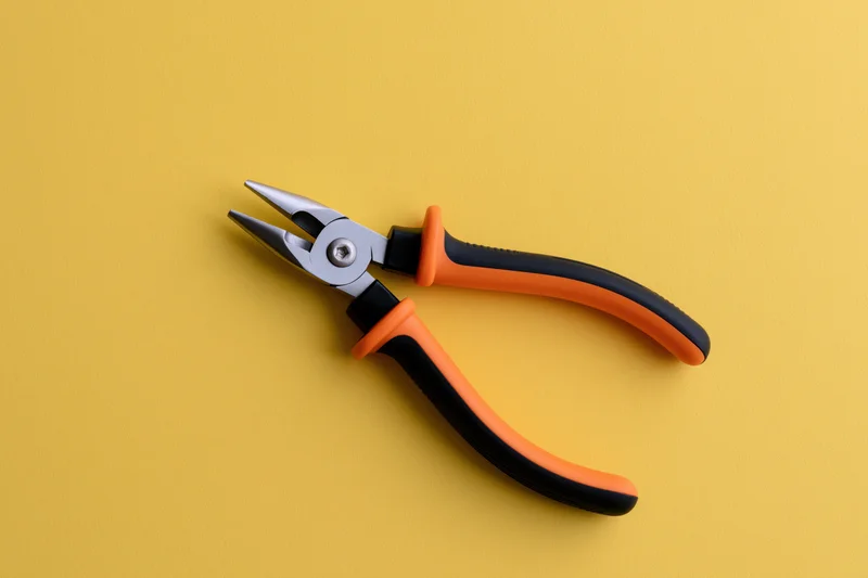 Needle-nose pliers open on a flat yellow background