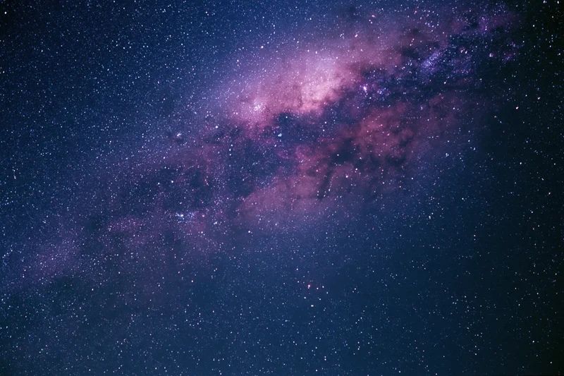Night sky filled with scattered stars and a dense milky way band across the frame