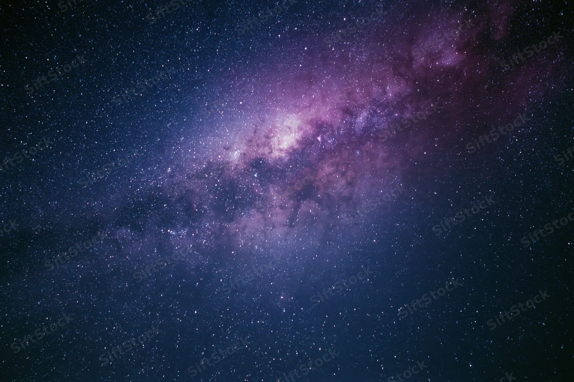 Night sky filled with scattered stars and a dense milky way band across the frame