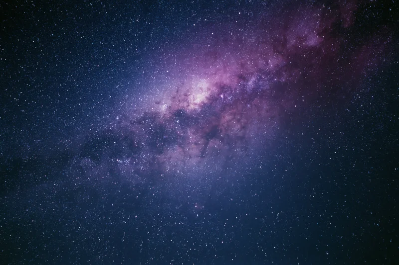 Night sky filled with scattered stars and a dense milky way band across the frame