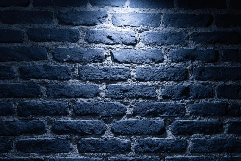 Old brick wall surface with spotlight creating shadows and texture