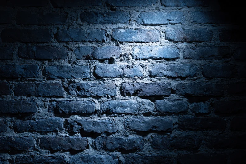 Old brick wall surface illuminated by spotlight in dark setting