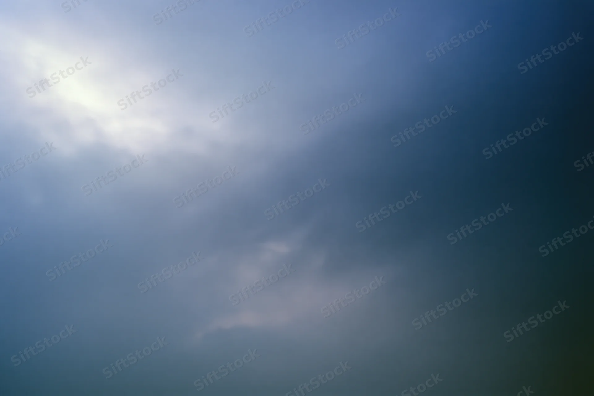 Overcast sky with diffused light at dusk showing soft gray and blue clouds across the frame