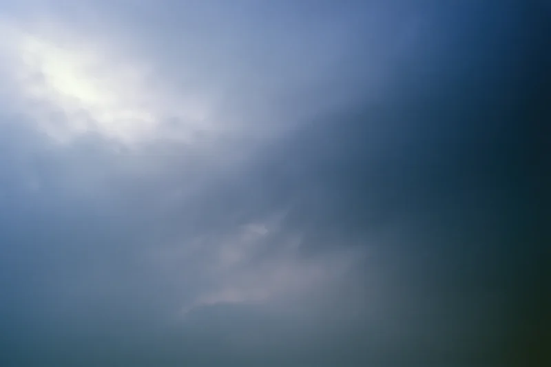 Overcast sky with diffused light at dusk showing soft gray and blue clouds across the frame