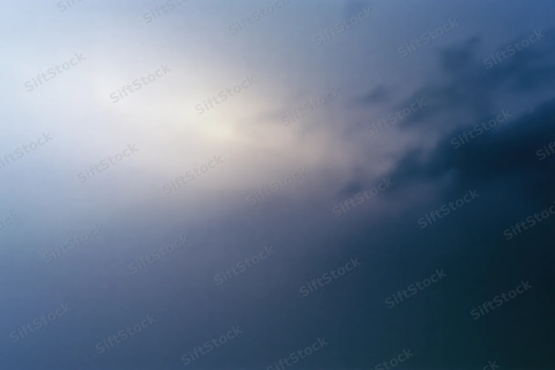 Overcast sky at dusk with soft light and dark clouds filling the frame