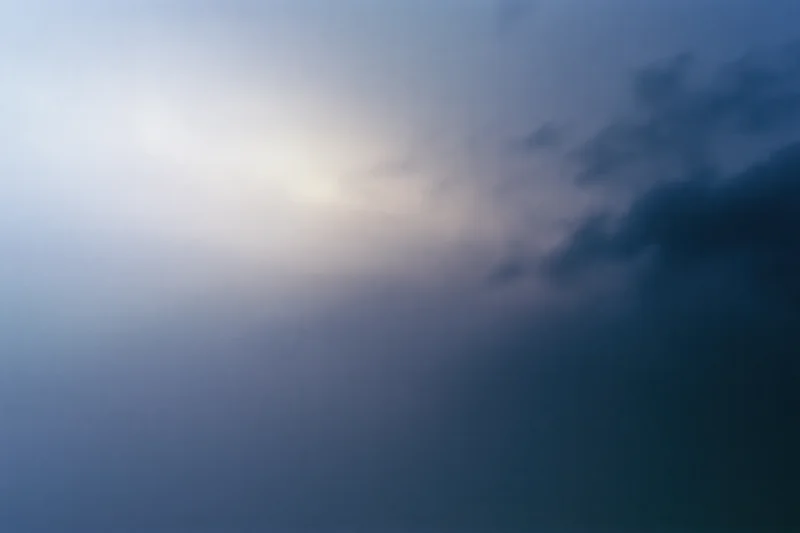 Overcast sky at dusk with soft light and dark clouds filling the frame