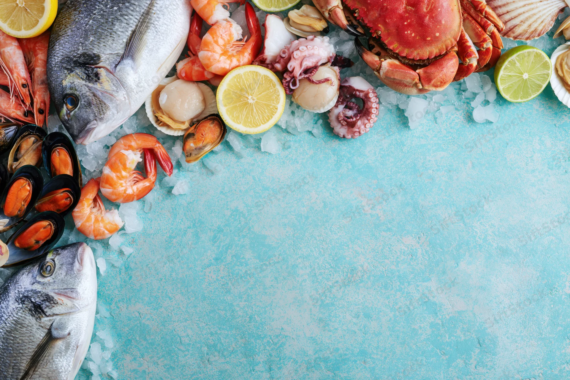 Fresh seafood arranged on ice with citrus slices along left edge on blue surface