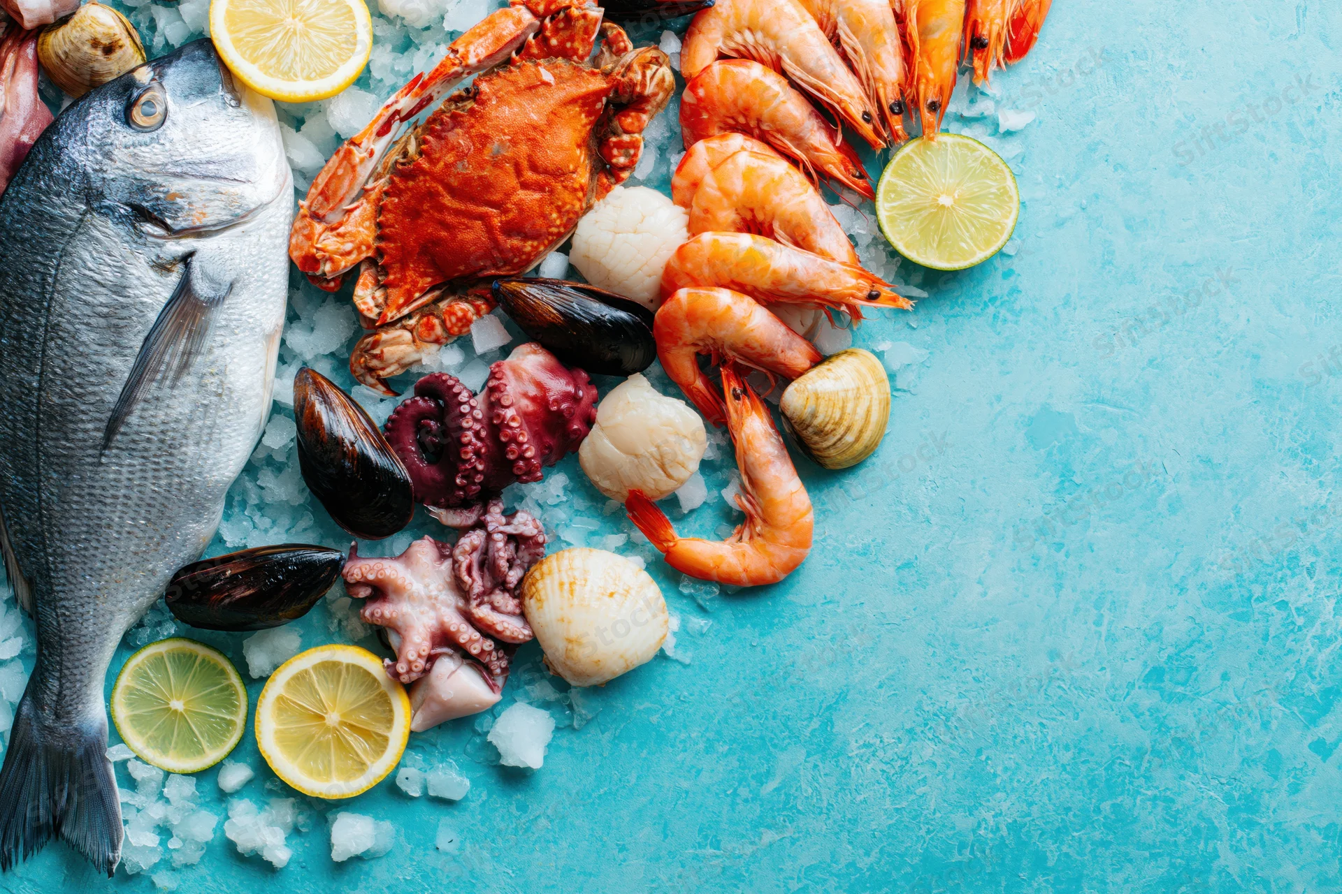 Fresh seafood arranged on ice with citrus slices on a blue surface