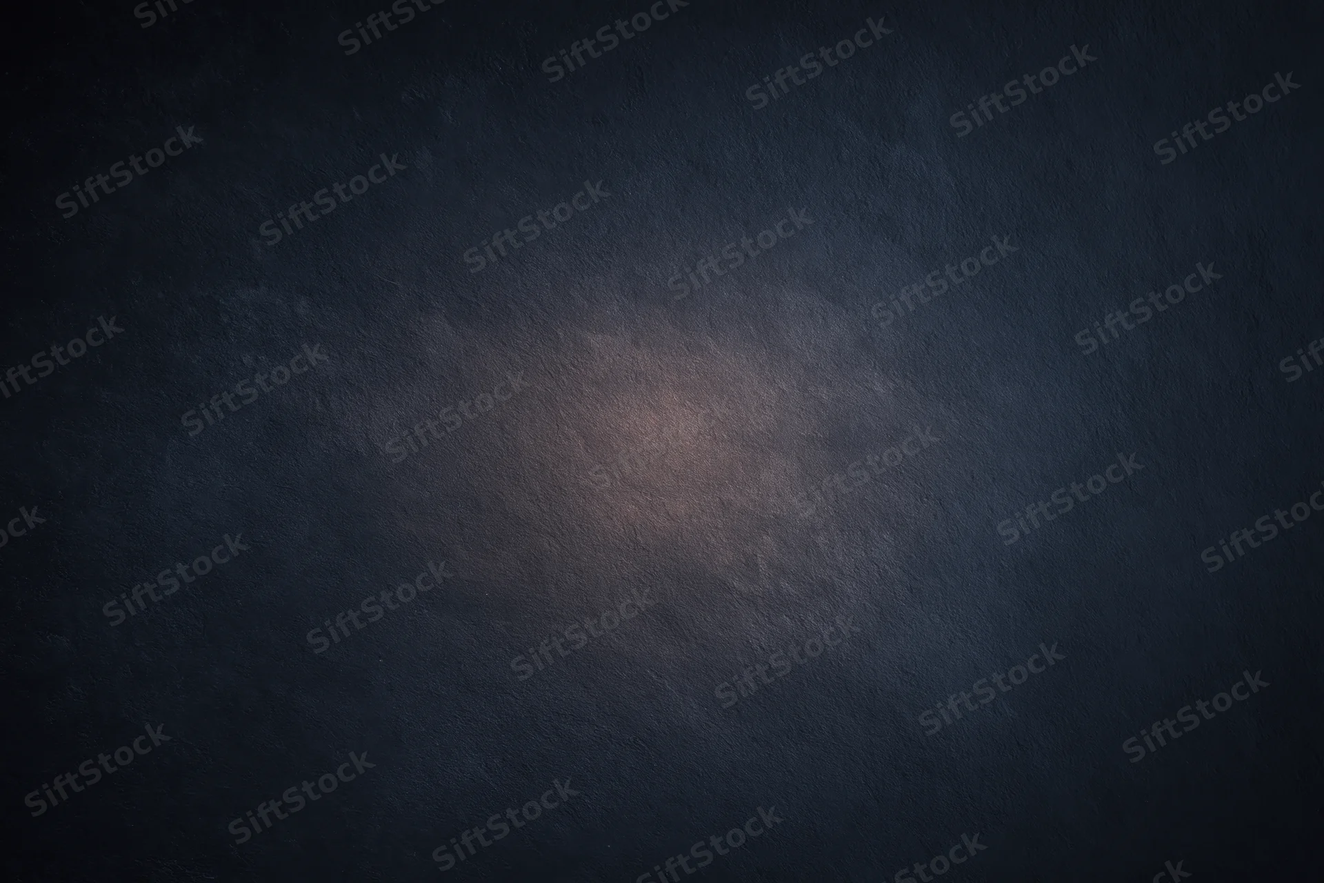 Dark textured surface with soft gradient lighting centered in the frame