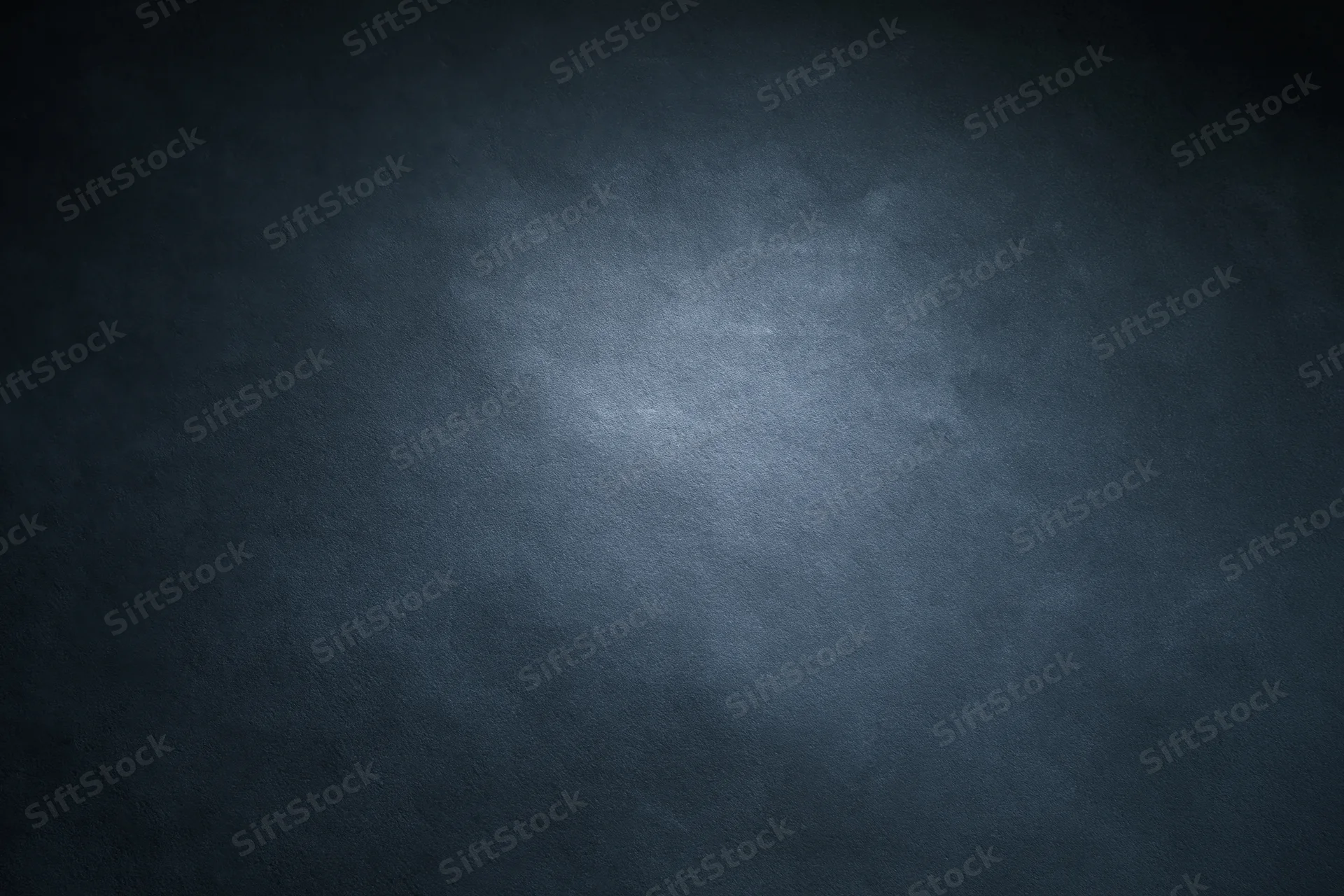 Dark charcoal textured studio backdrop with centered spotlight and vignette effect