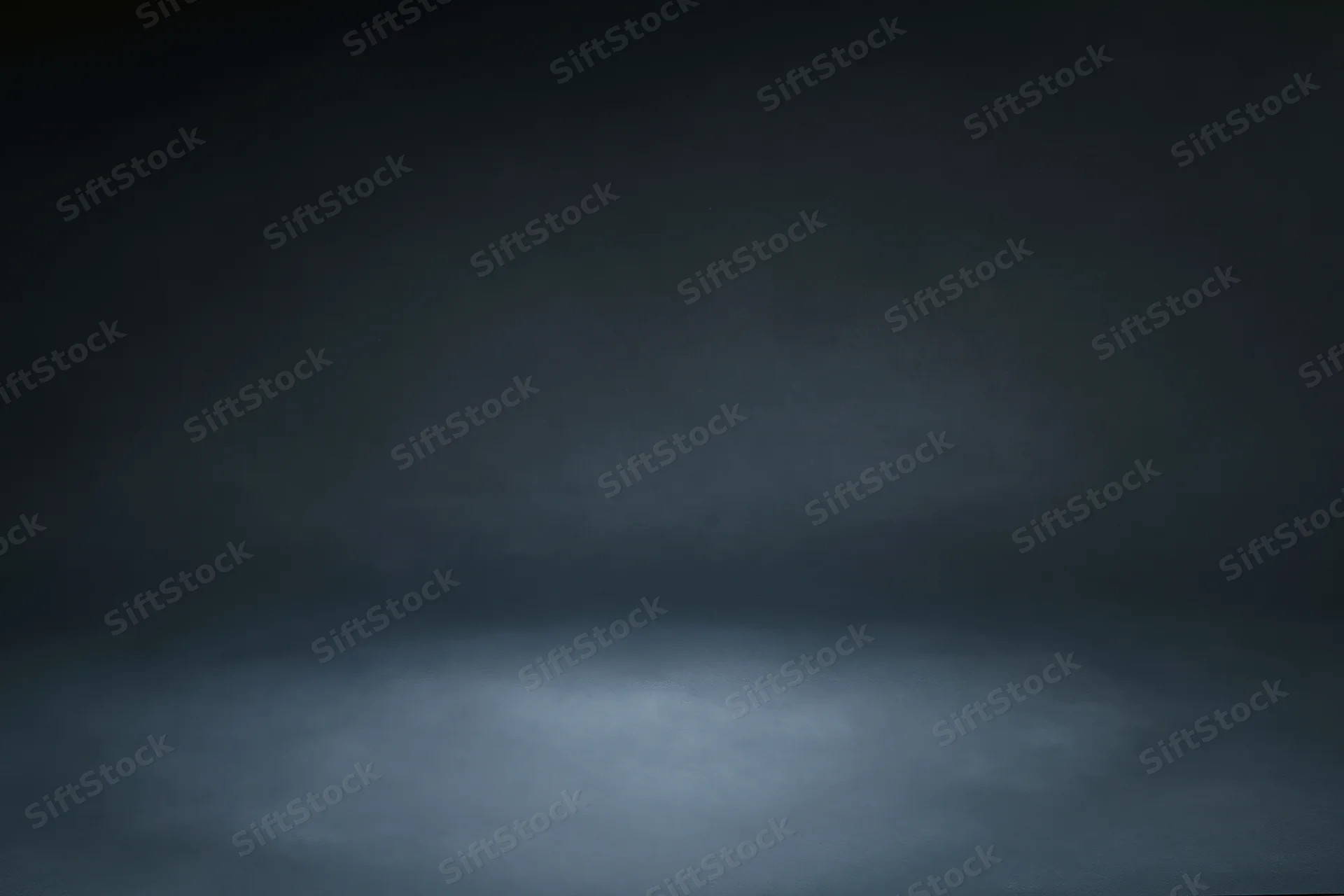Dark charcoal studio backdrop with centered spotlight and gradient lighting