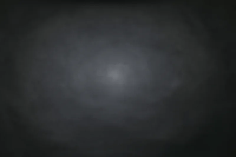 Dark charcoal studio backdrop with subtle centered light gradient