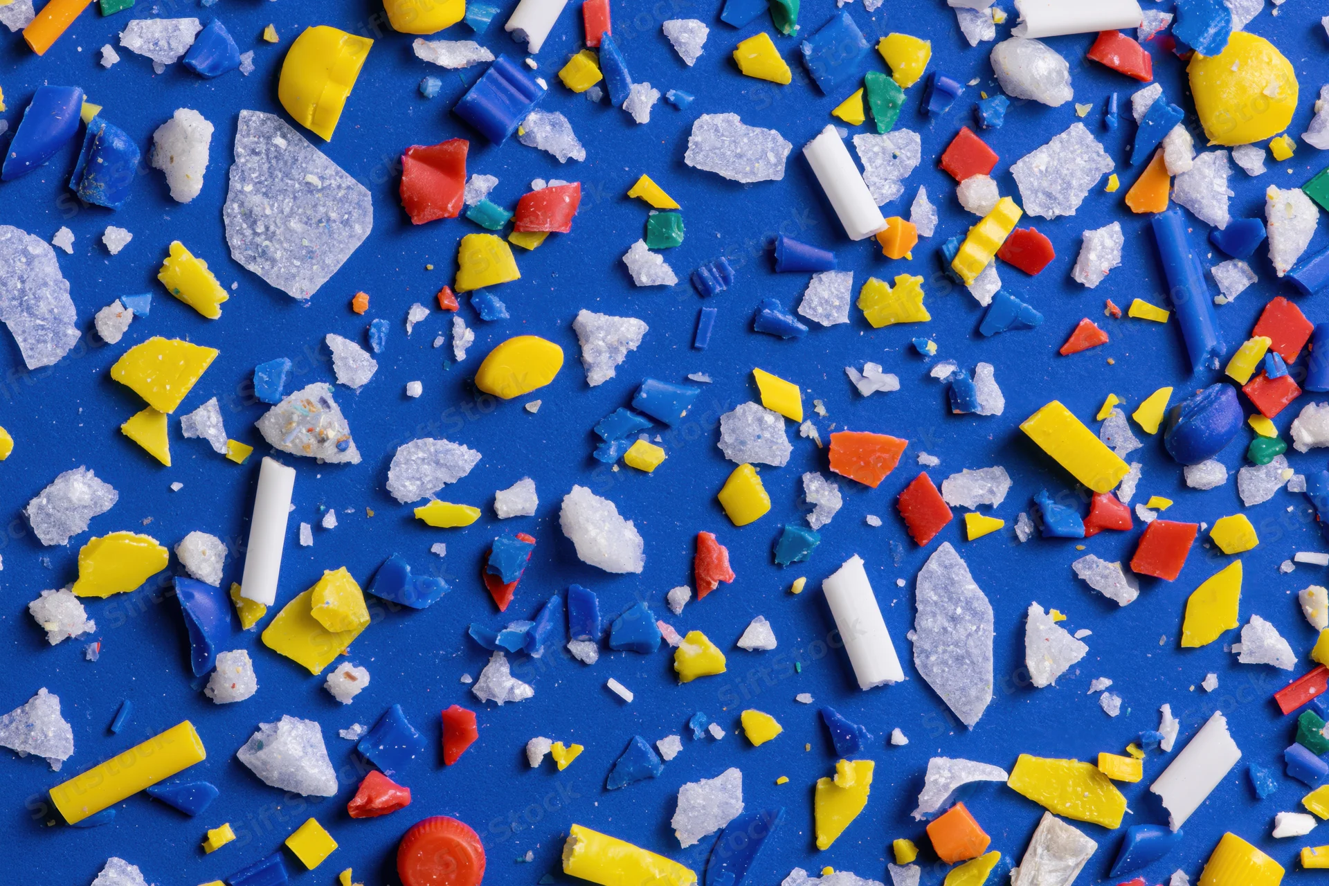 Scattered colorful plastic fragments on blue surface